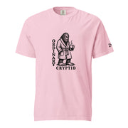 Black ink illustration of Bigfoot wearing a tied bathrobe and holding a steaming mug above the words “Ordinary Cryptid,” shown on a unisex t-shirt.