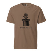 Black vintage-style illustration of a blooming flower growing from a magician's top hat with the words "Dirt Magic" beneath it, rendered in bold botanical line art inspired by classic storybook illustrations on a t-shirt.