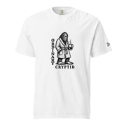 Black ink illustration of Bigfoot wearing a tied bathrobe and holding a steaming mug above the words “Ordinary Cryptid,” shown on a unisex t-shirt.