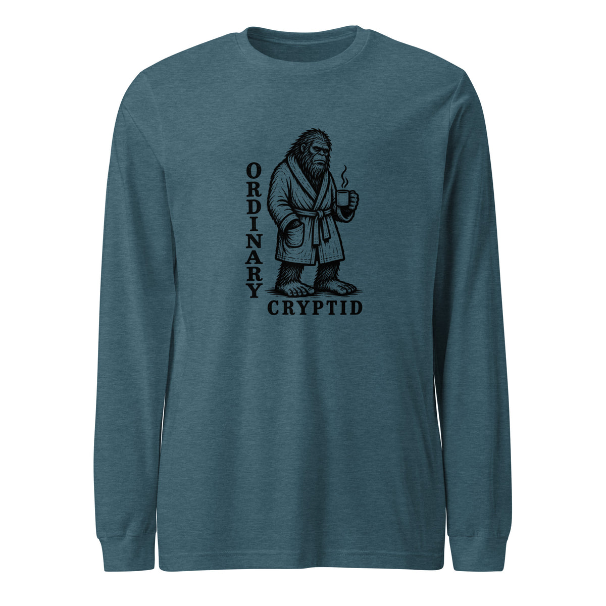 Black ink illustration of Bigfoot wearing a tied bathrobe and holding a steaming mug above the words “Ordinary Cryptid,” shown on a long sleeve tee.