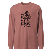 Black ink illustration of Bigfoot wearing a tied bathrobe and holding a steaming mug above the words “Ordinary Cryptid,” shown on a long sleeve tee.