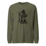 Black ink illustration of Bigfoot wearing a tied bathrobe and holding a steaming mug above the words “Ordinary Cryptid,” shown on a long sleeve tee.
