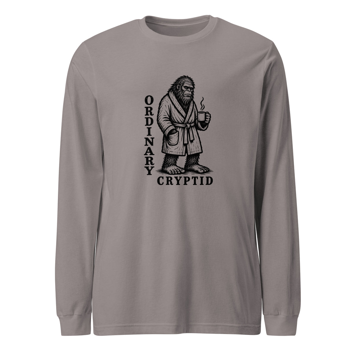 Black ink illustration of Bigfoot wearing a tied bathrobe and holding a steaming mug above the words “Ordinary Cryptid,” shown on a long sleeve tee.