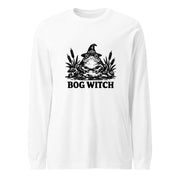 Black ink folk art illustration of a wide-eyed frog beneath an oversized pointed witch hat surrounded by cattails and marsh plants, with the words “BOG WITCH,” on a long sleeve tee.