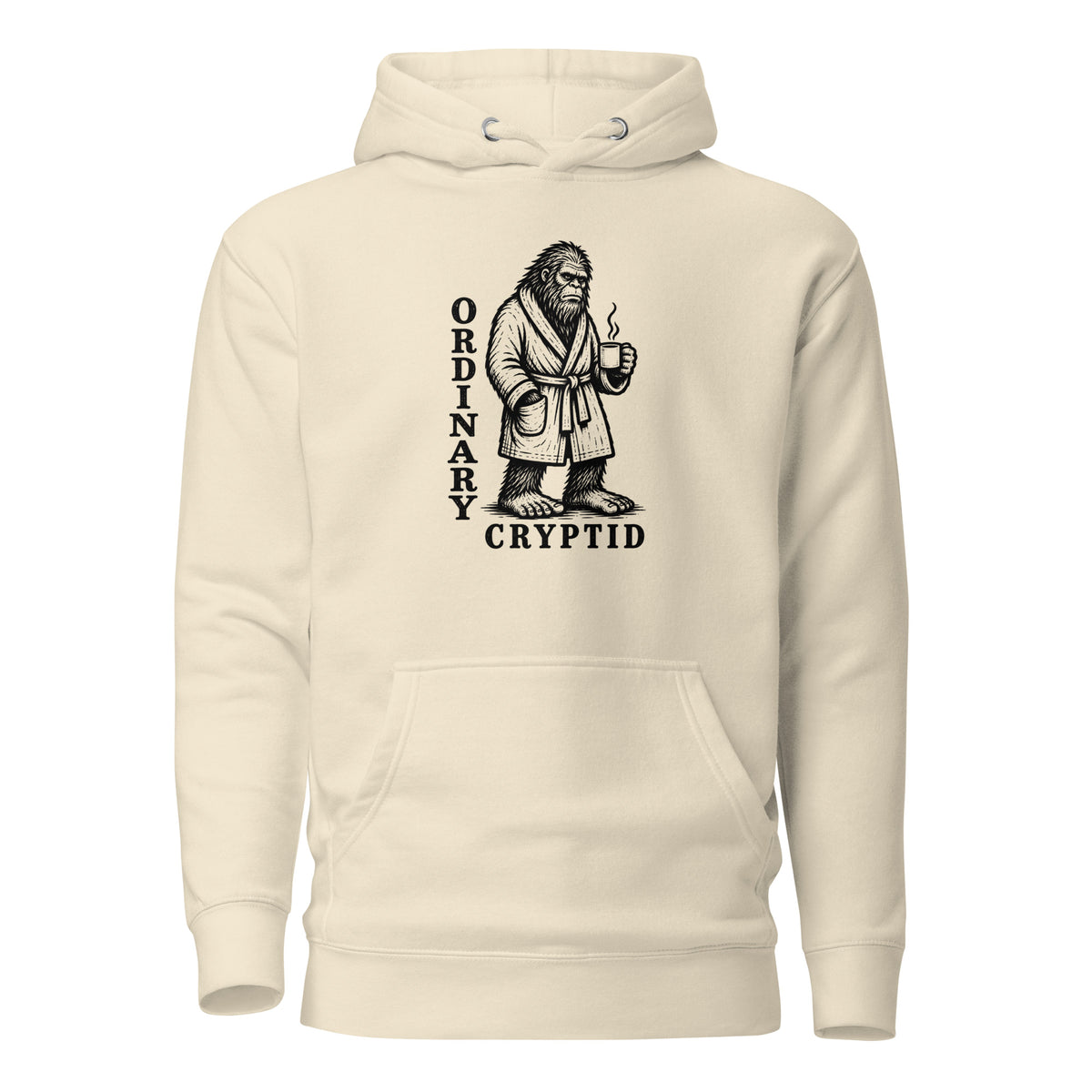Black ink illustration of Bigfoot wearing a tied bathrobe and holding a steaming mug above the words “Ordinary Cryptid,” shown on a hoodie.