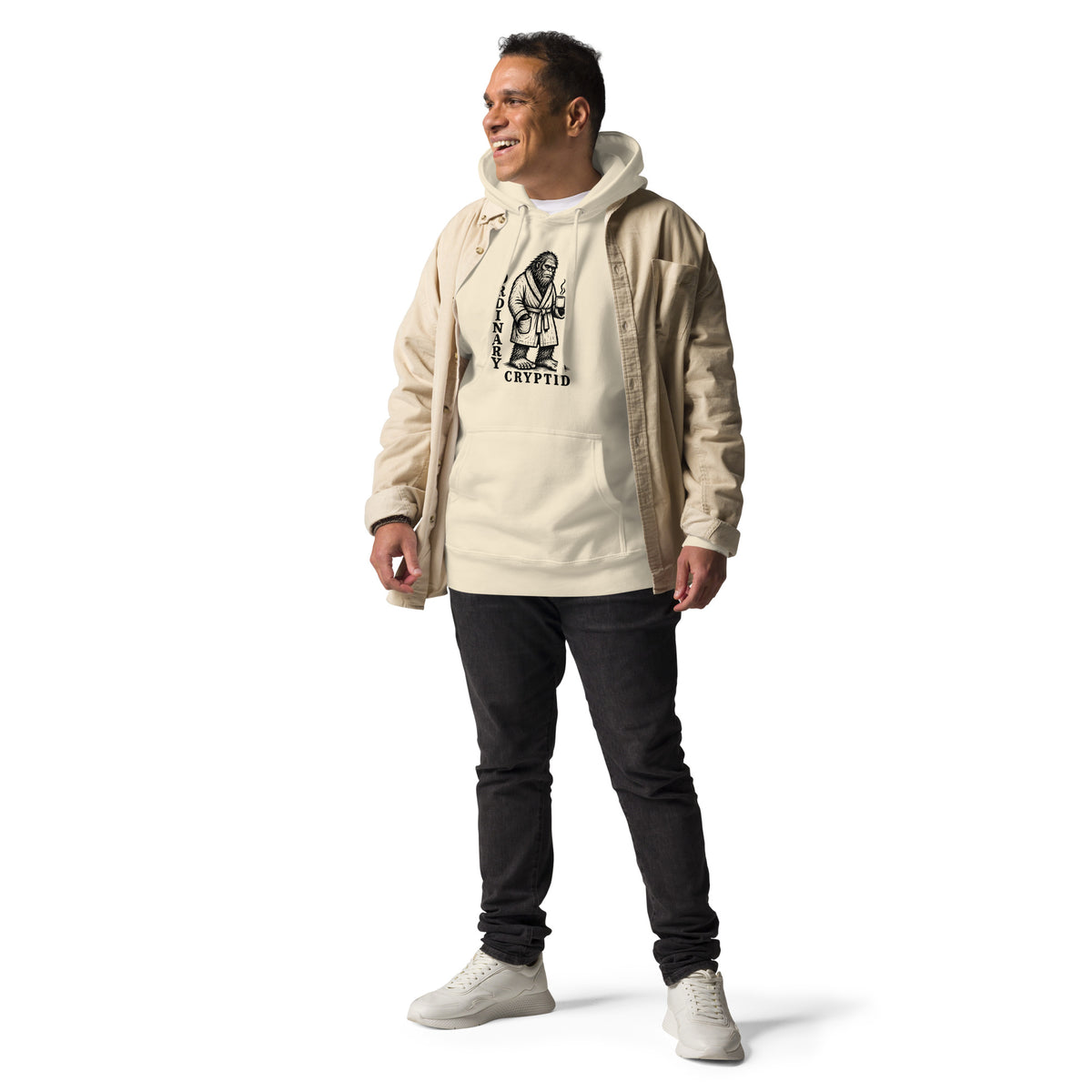 Black ink illustration of Bigfoot wearing a tied bathrobe and holding a steaming mug above the words “Ordinary Cryptid,” shown on a hoodie.