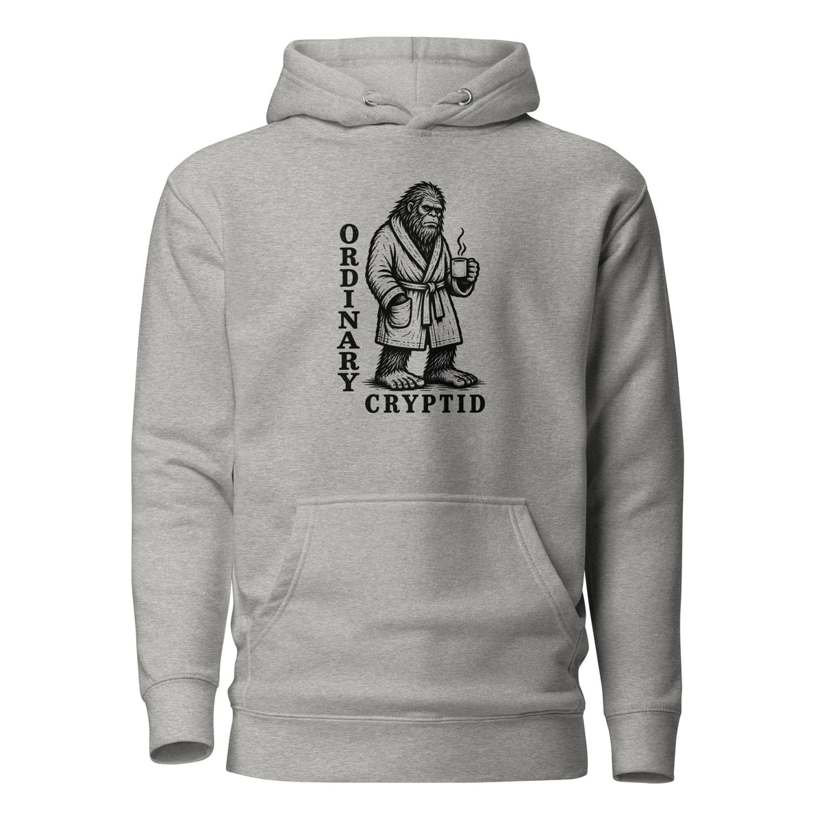 Black ink illustration of Bigfoot wearing a tied bathrobe and holding a steaming mug above the words “Ordinary Cryptid,” shown on a hoodie.