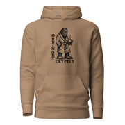 Black ink illustration of Bigfoot wearing a tied bathrobe and holding a steaming mug above the words “Ordinary Cryptid,” shown on a hoodie.