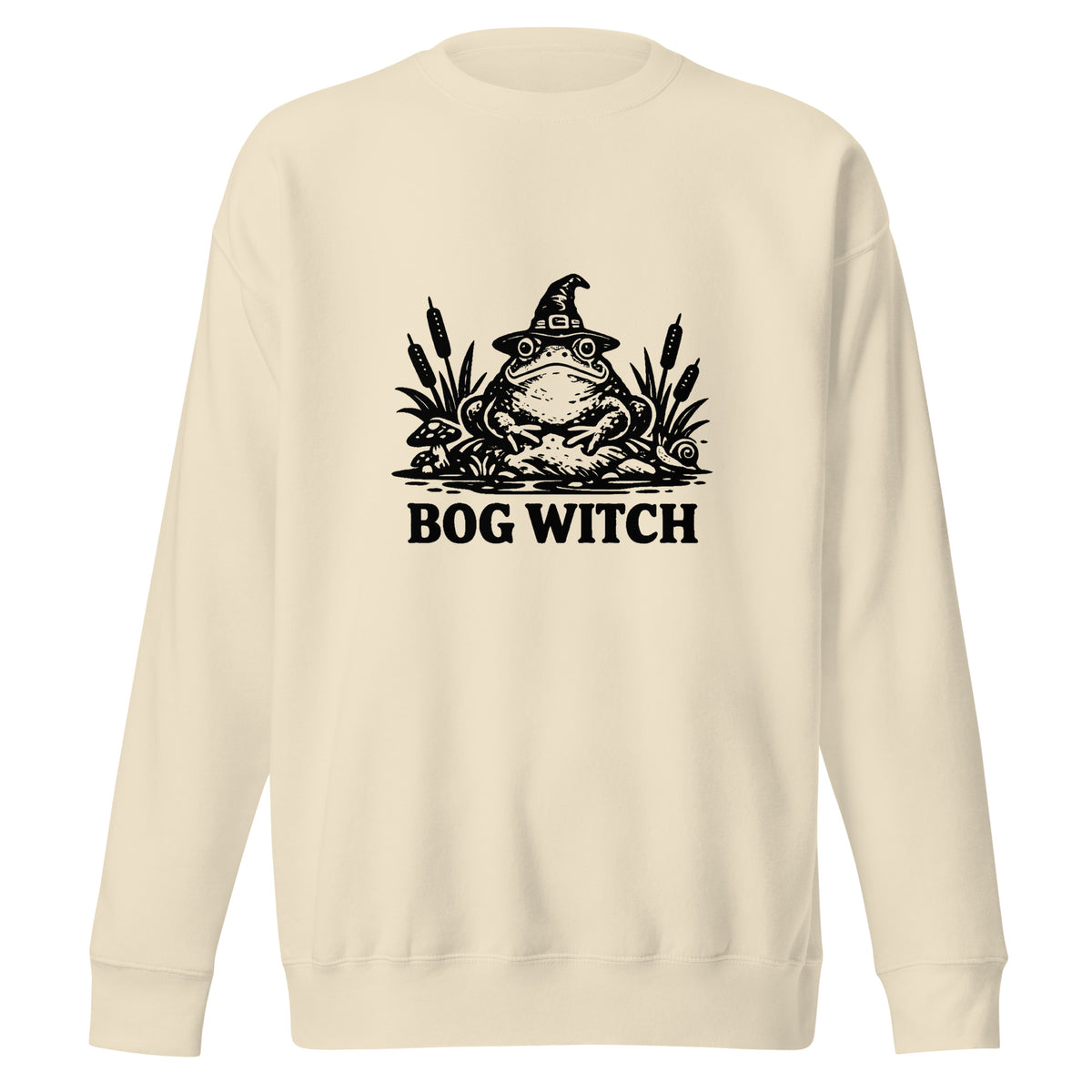 Black ink folk art illustration of a wide-eyed frog beneath an oversized pointed witch hat surrounded by cattails and marsh plants, with the words “BOG WITCH,” on a sweatshirt.