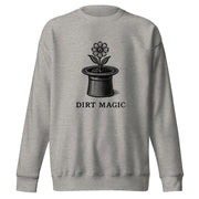 Black vintage-style illustration of a blooming flower growing from a magician's top hat with the words "Dirt Magic" beneath it, rendered in bold botanical line art inspired by classic storybook illustrations on a sweatshirt.