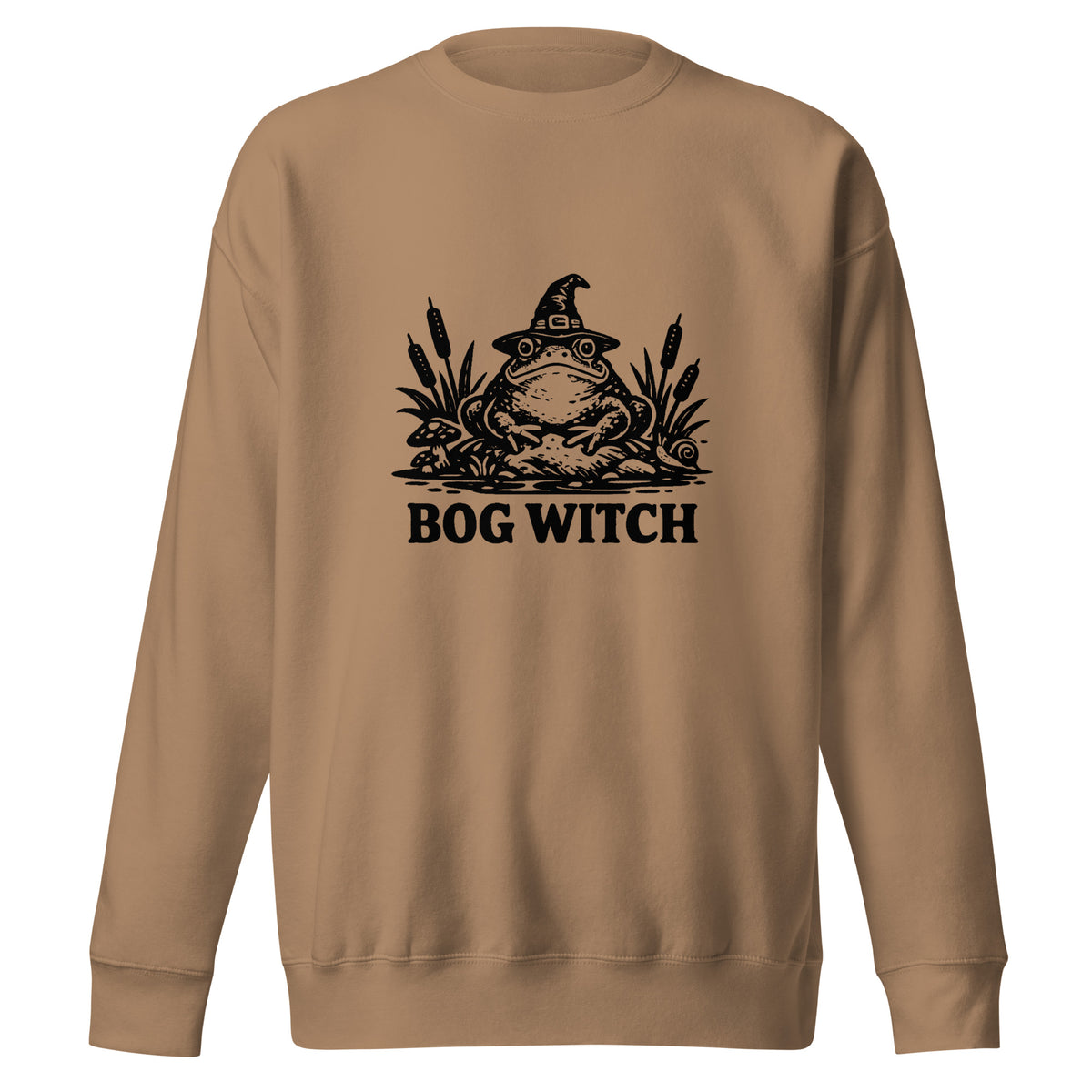 Black ink folk art illustration of a wide-eyed frog beneath an oversized pointed witch hat surrounded by cattails and marsh plants, with the words “BOG WITCH,” on a sweatshirt.
