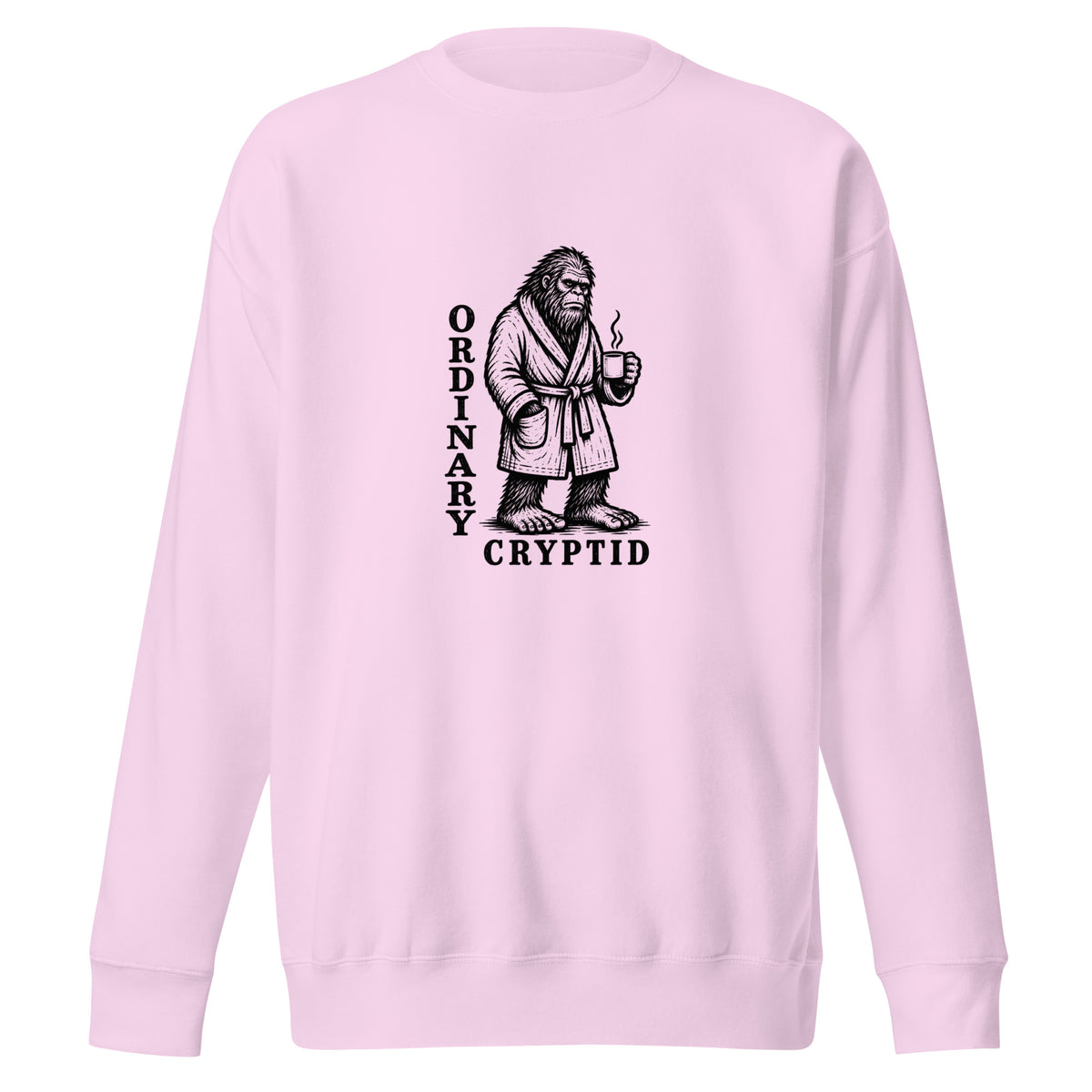 Black ink illustration of Bigfoot wearing a tied bathrobe and holding a steaming mug above the words “Ordinary Cryptid,” shown on a sweatshirt.